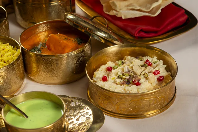Up close: a bowl of kheer with pistachio and pomegranate, and another of tikka masala