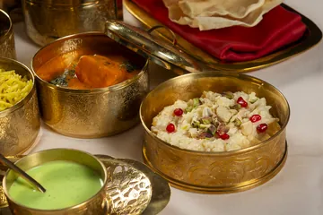 Up close: a bowl of kheer with pistachio and pomegranate, and another of tikka masala