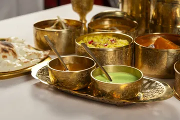 The two Lunch box sauces, one amber and one green, in brass bowls