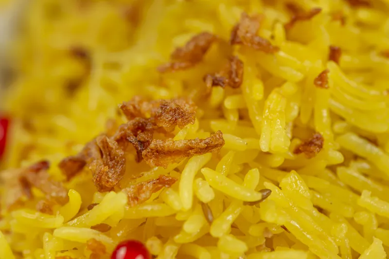 Yellow rice up close, with fried onion on top